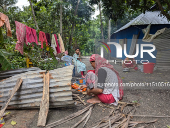 People cook food on the street during a flood in Feni, Bangladesh, on August 25, 2024. (