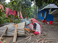 People cook food on the street during a flood in Feni, Bangladesh, on August 25, 2024. (