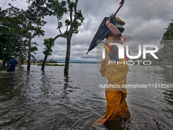 A woman wades through floodwaters in Feni, Bangladesh, on August 25, 2024. (