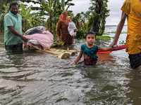 People wade through floodwaters in Feni, Bangladesh, on August 25, 2024. (