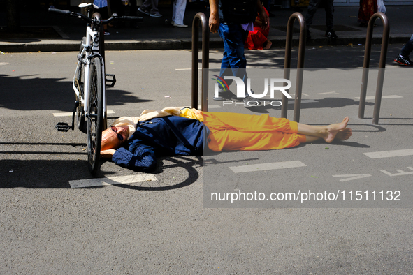 A Hare Krishna devotee sleeps on the road during the 27th Ganesh festival in Paris, France, on September 1, 2019, in Paris, France, on Augus...