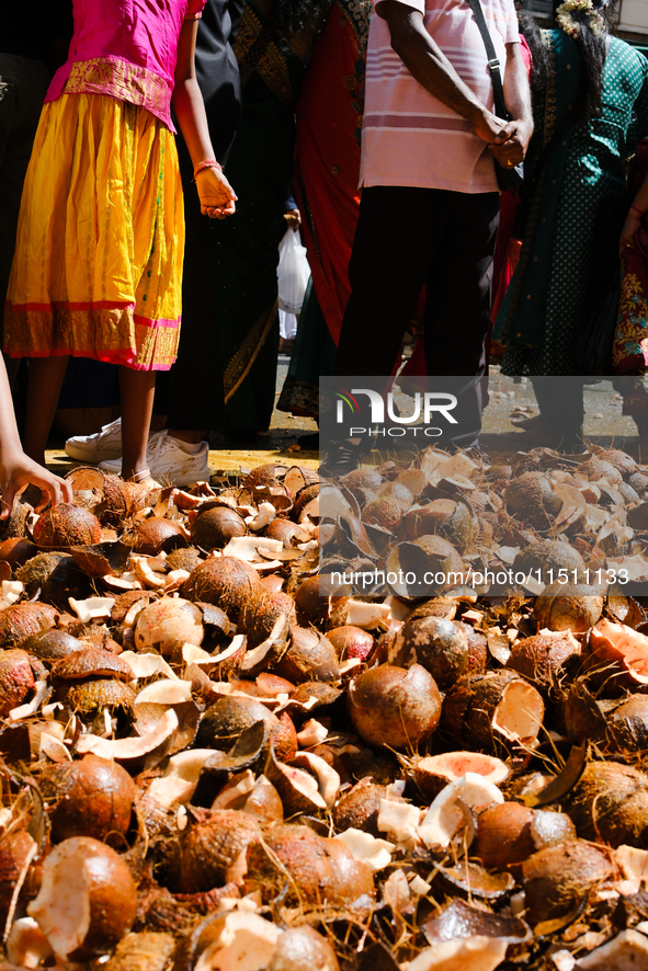 People participate in the Ganesh Chaturthi procession and walk past coconuts during the 27th Ganesh festival in Paris, France, on September...