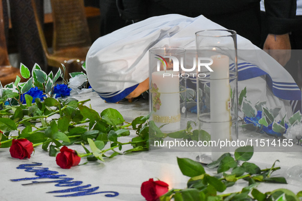 A sister of Missionaries of Charity prays in front of Saint Teresa's tomb on the occasion of Saint Teresa's birthday at Mother House in Kolk...