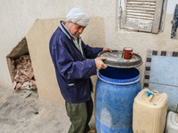 A man fills plastic jerry cans and barrels with drinking water at his home in a rural area in Kairouan, Tunisia, on May 8, 2024. As the regi...