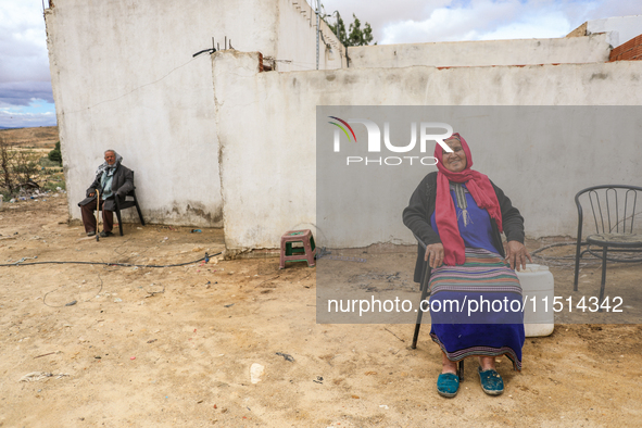 An old Tunisian woman with Berber tattoos on her face poses for photos with her husband in a rural area in Kairouan, Tunisia, on May 8, 2024...