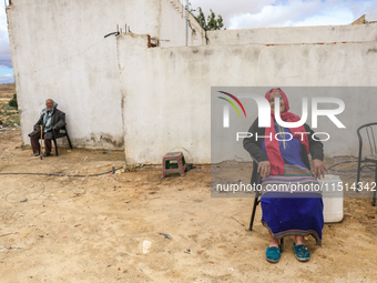 An old Tunisian woman with Berber tattoos on her face poses for photos with her husband in a rural area in Kairouan, Tunisia, on May 8, 2024...