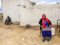 An old Tunisian woman with Berber tattoos on her face poses for photos with her husband in a rural area in Kairouan, Tunisia, on May 8, 2024...