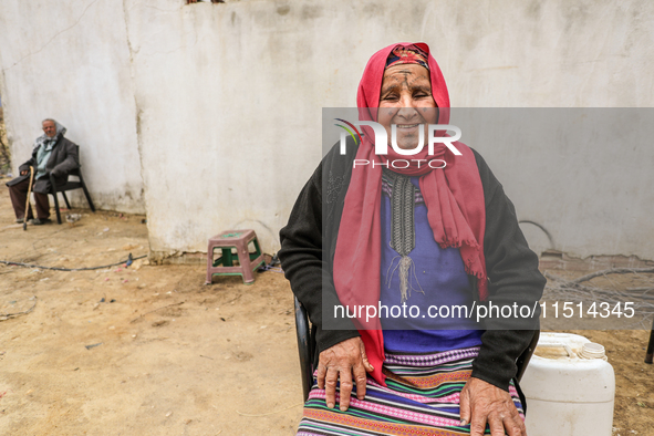 An old Tunisian woman with Berber tattoos on her face poses for photos with her husband in a rural area in Kairouan, Tunisia, on May 8, 2024...