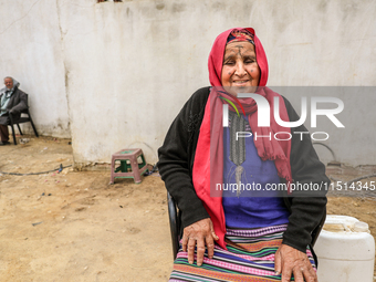 An old Tunisian woman with Berber tattoos on her face poses for photos with her husband in a rural area in Kairouan, Tunisia, on May 8, 2024...