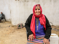 An old Tunisian woman with Berber tattoos on her face poses for photos with her husband in a rural area in Kairouan, Tunisia, on May 8, 2024...