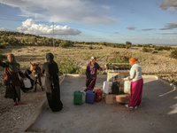 Rural women fill plastic cans with water at a drinking water point in the isolated rural area of Chrichira located in Kairouan, Tunisia, on...