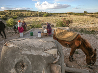 Rural women fill plastic cans with water at a drinking water point in the isolated rural area of Chrichira located in Kairouan, Tunisia, on...