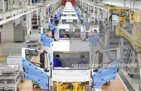 Workers work on an automobile production line at BYD Industrial Co LTD in Huai'an, China, on August 26, 2024. 