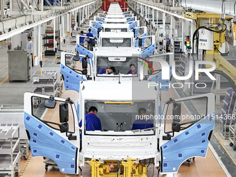 Workers work on an automobile production line at BYD Industrial Co LTD in Huai'an, China, on August 26, 2024. (