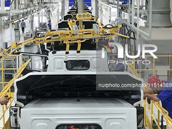 Workers work on an automobile production line at BYD Industrial Co LTD in Huai'an, China, on August 26, 2024. (