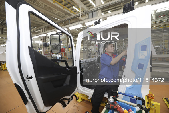 A worker works on an automobile production line at BYD Industrial Co LTD in Huai'an, China, on August 26, 2024. 