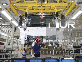 A worker works on an automobile production line at BYD Industrial Co LTD in Huai'an, China, on August 26, 2024. (