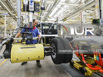 A worker works on an automobile production line at BYD Industrial Co LTD in Huai'an, China, on August 26, 2024. (