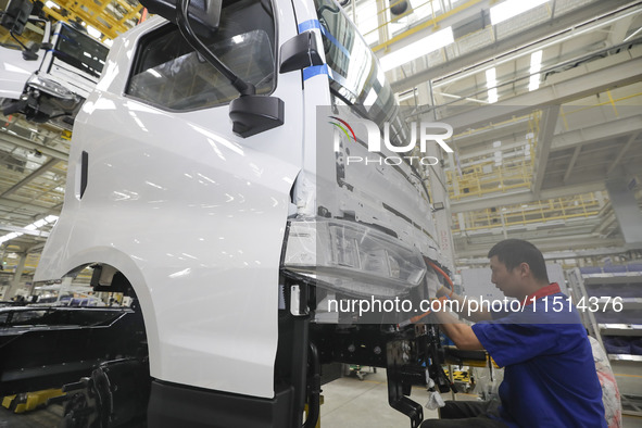 A worker works on an automobile production line at BYD Industrial Co LTD in Huai'an, China, on August 26, 2024. 