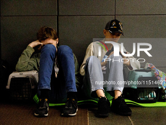 People with their pets in carriers wait out an air raid alarm at the Teatralna metro station during the massive Russian drone and missile at...