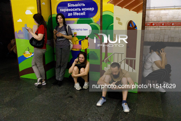 People wait out an air raid alarm at the Teatralna metro station during the massive Russian drone and missile attack on Ukraine in Kyiv, Ukr...