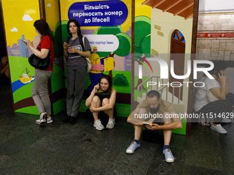 People wait out an air raid alarm at the Teatralna metro station during the massive Russian drone and missile attack on Ukraine in Kyiv, Ukr...