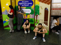 People wait out an air raid alarm at the Teatralna metro station during the massive Russian drone and missile attack on Ukraine in Kyiv, Ukr...