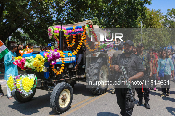 Indian policemen guard as Kashmiri Hindus celebrate the Janmashtami festival that marks the birthday of Hindu god Krishna with a procession...