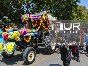 Indian policemen guard as Kashmiri Hindus celebrate the Janmashtami festival that marks the birthday of Hindu god Krishna with a procession...