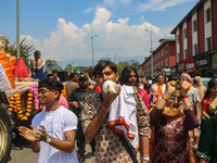 A Hindu devotee blows a conch shell as they celebrate the Janmashtami festival that marks the birthday of the Hindu god Krishna with a proce...