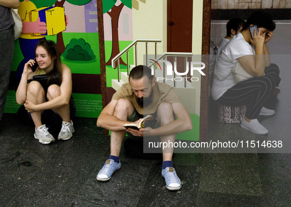 People wait out an air raid alarm at the Teatralna metro station during the massive Russian drone and missile attack on Ukraine in Kyiv, Ukr...