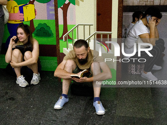 People wait out an air raid alarm at the Teatralna metro station during the massive Russian drone and missile attack on Ukraine in Kyiv, Ukr...