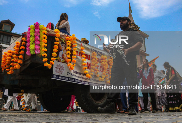 An Indian policeman guards as Kashmiri Hindus celebrate the Janmashtami festival that marks the birthday of the Hindu god Krishna with a pro...