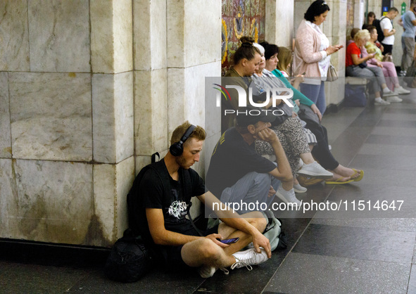 People wait out an air raid alarm at the Khreshchatyk metro station during the massive Russian drone and missile attack on Ukraine in Kyiv,...