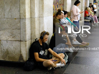 People wait out an air raid alarm at the Khreshchatyk metro station during the massive Russian drone and missile attack on Ukraine in Kyiv,...