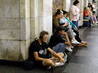 People wait out an air raid alarm at the Khreshchatyk metro station during the massive Russian drone and missile attack on Ukraine in Kyiv,...