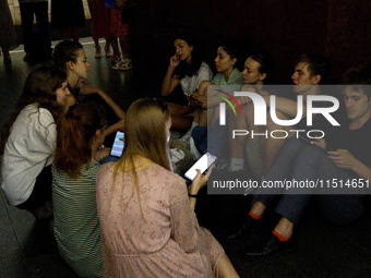 People wait out an air raid alarm at the Teatralna metro station during the massive Russian drone and missile attack on Ukraine in Kyiv, Ukr...