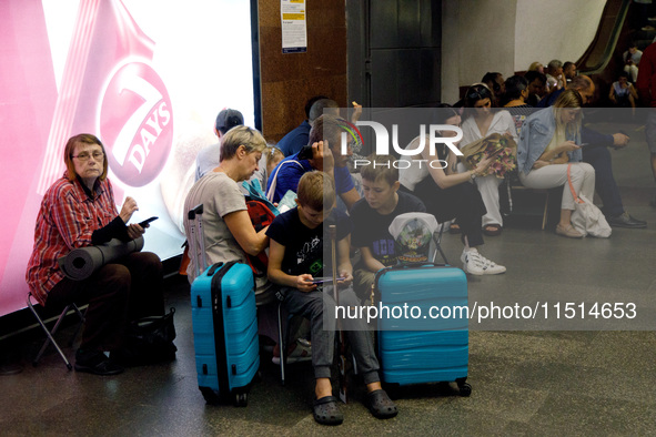 People wait out an air raid alarm at the Teatralna metro station during the massive Russian drone and missile attack on Ukraine in Kyiv, Ukr...