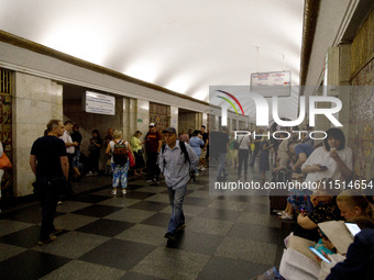 People wait out an air raid alarm at the Khreshchatyk metro station during the massive Russian drone and missile attack on Ukraine in Kyiv,...