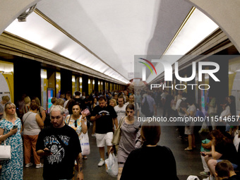 People wait out an air raid alarm at the Teatralna metro station during the massive Russian drone and missile attack on Ukraine in Kyiv, Ukr...