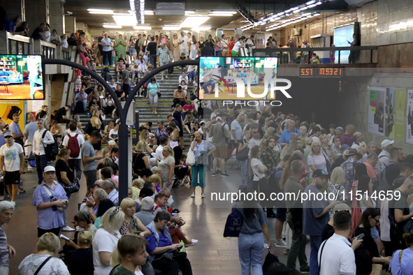 People wait out an air raid alarm at the Pozniaky metro station during the massive Russian drone and missile attack on Ukraine in Kyiv, Ukra...