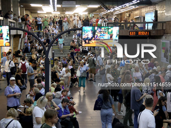 People wait out an air raid alarm at the Pozniaky metro station during the massive Russian drone and missile attack on Ukraine in Kyiv, Ukra...