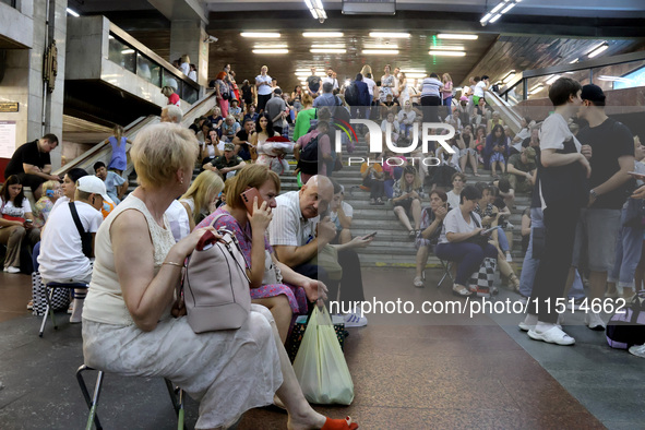 People wait out an air raid alarm at the Pozniaky metro station during the massive Russian drone and missile attack on Ukraine in Kyiv, Ukra...