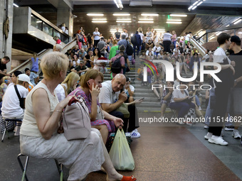 People wait out an air raid alarm at the Pozniaky metro station during the massive Russian drone and missile attack on Ukraine in Kyiv, Ukra...