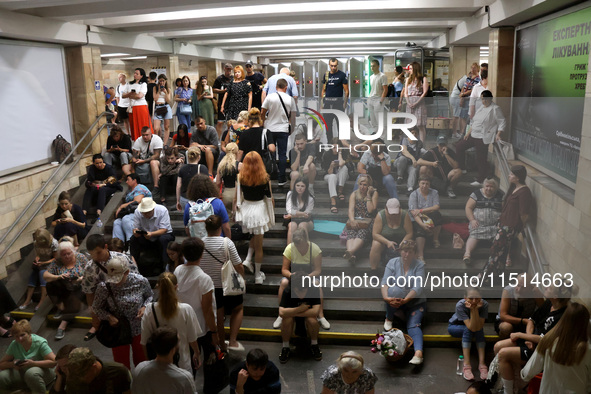 People sit on the steps during an air raid alarm at the Osokorky metro station during the massive Russian drone and missile attack on Ukrain...