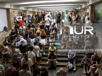 People sit on the steps during an air raid alarm at the Osokorky metro station during the massive Russian drone and missile attack on Ukrain...