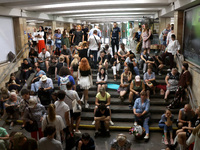 People sit on the steps during an air raid alarm at the Osokorky metro station during the massive Russian drone and missile attack on Ukrain...