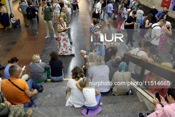 People wait out an air raid alarm at the Pozniaky metro station during the massive Russian drone and missile attack on Ukraine in Kyiv, Ukra...