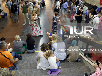 People wait out an air raid alarm at the Pozniaky metro station during the massive Russian drone and missile attack on Ukraine in Kyiv, Ukra...