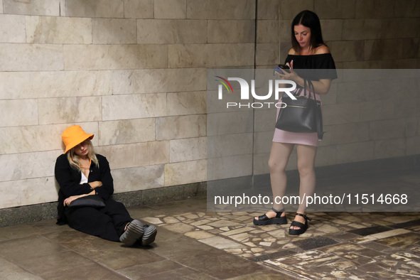 Two women stand at the Osokorky metro station during the massive Russian drone and missile attack on Ukraine in Kyiv, Ukraine, on August 26,...